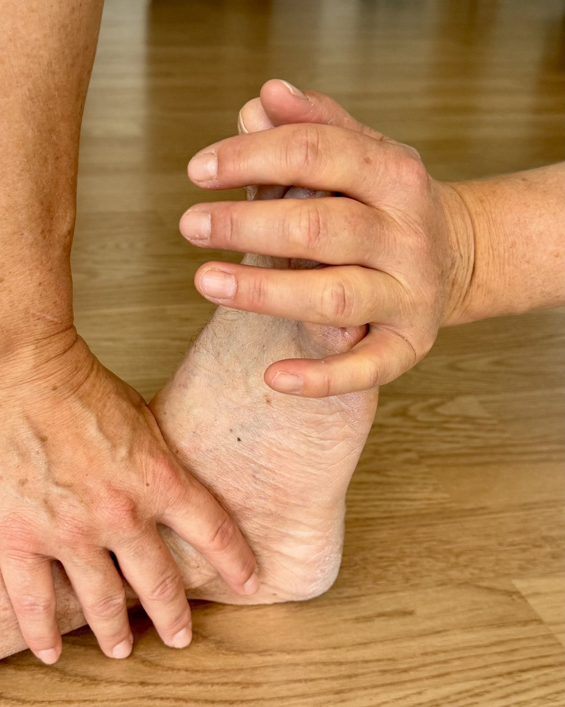 Physiotherapeutische Behandlung – Hände an Fuss und Knöchel